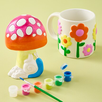 Kids spring crafting with paint pot next to the craft. 