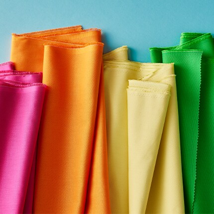 pink, orange, yellow and green fabrics on blue background