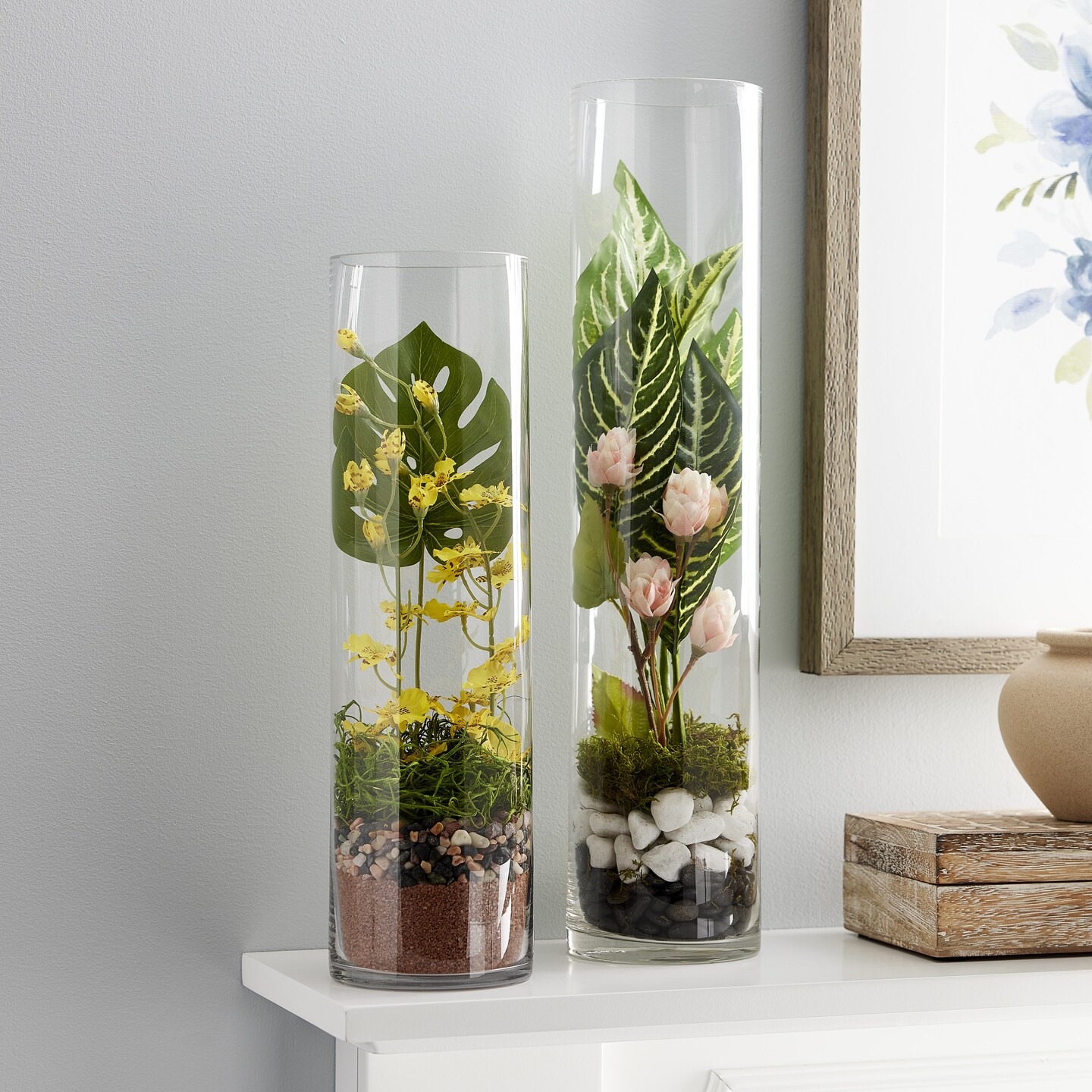 glass vases filled with rocks and plants