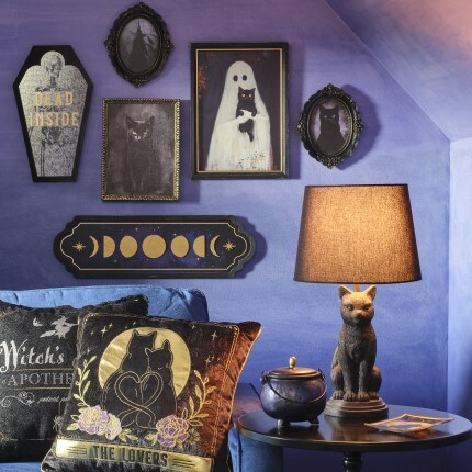 Halloween Iridescent Moon Decor Collection showing wall decor, a pillow and a lamp in purple and darks colors.