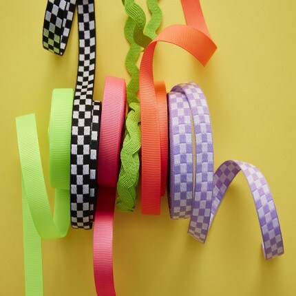 Assorted ribbon colors and patters lined up together on yellow background