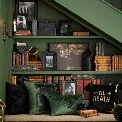 green inset bookcase with gothic black accents and dark green pillows