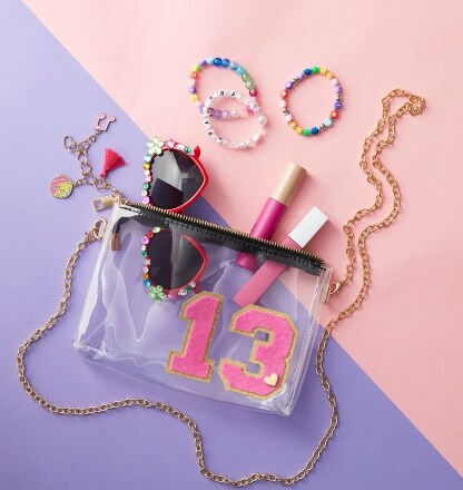 clear bag with sunglasses, lipstick and bracelets