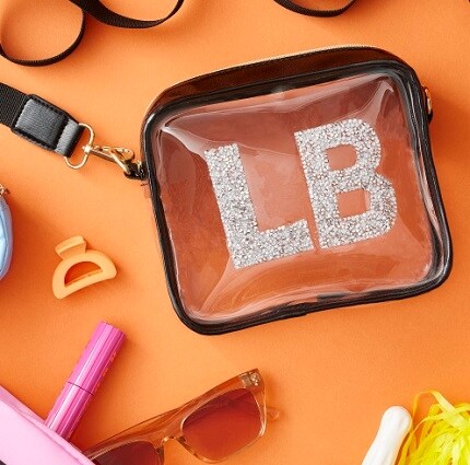 clear bag with sunglasses, lipstick and bracelets