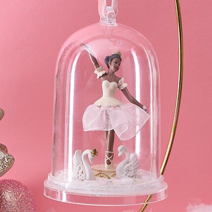 ballerina in ornament in front of pink wall