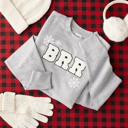 gray sweatshirt on plaid background with winter accessories