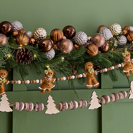Garlands of Christmas balls and gingerbread men on a mantel