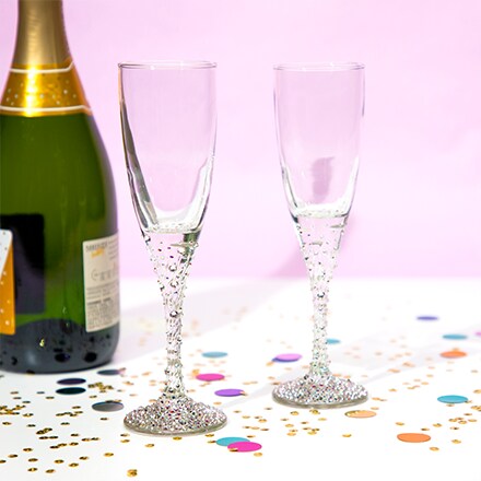 champagne glasses with bottle on table with confetti