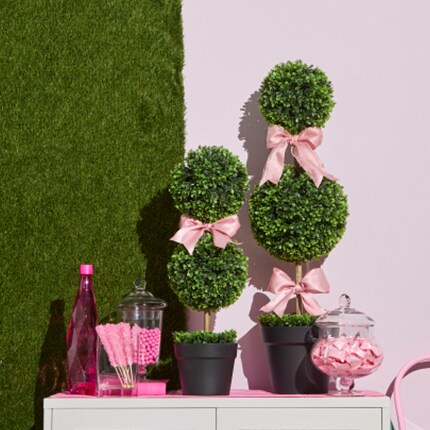 boxwood two ball topiary plant on table outside with bows and refreshments