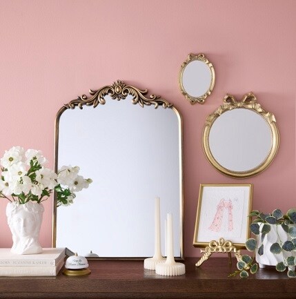 three decorative mirrors on pink wall