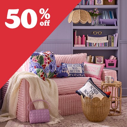 pink couch in purple room with 50% off in white text over red triangle