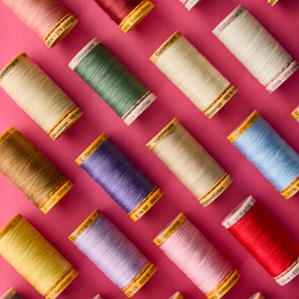 Spools of Guterman thread on pink background