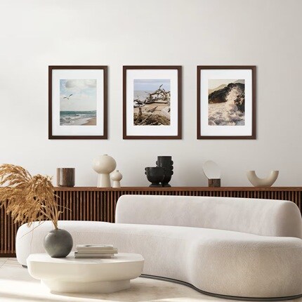 three brown frames with beach photographs on wall in mod living room