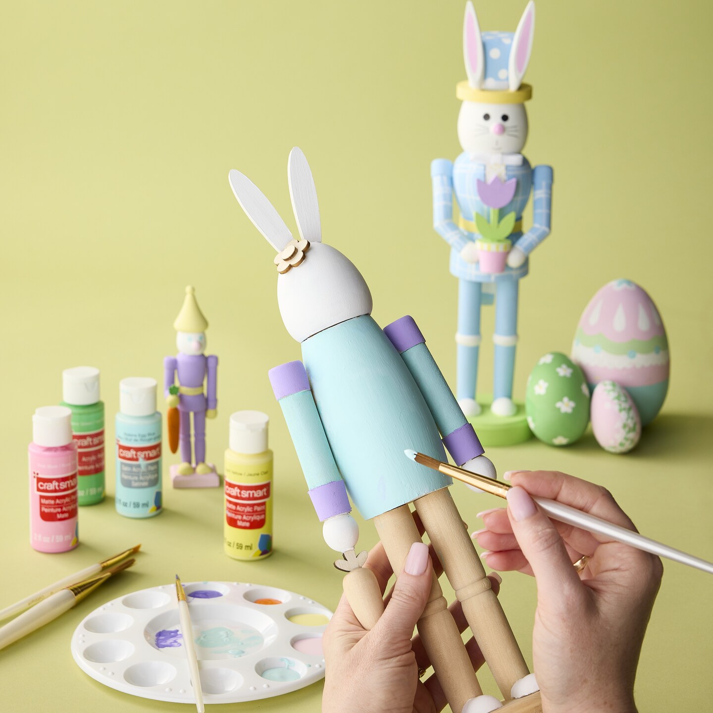 Easter bunny nutcrackers being painted with craft paint