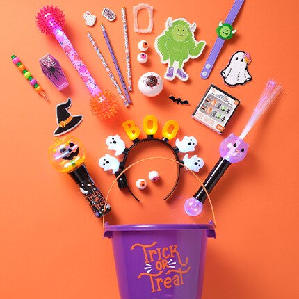 purple bucket with kids toys laid out on orange table