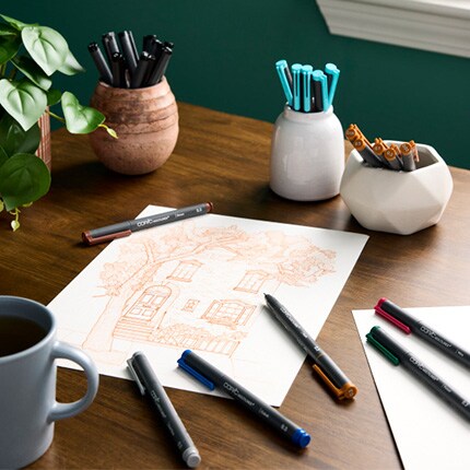 markers with drawing paper on wood desk