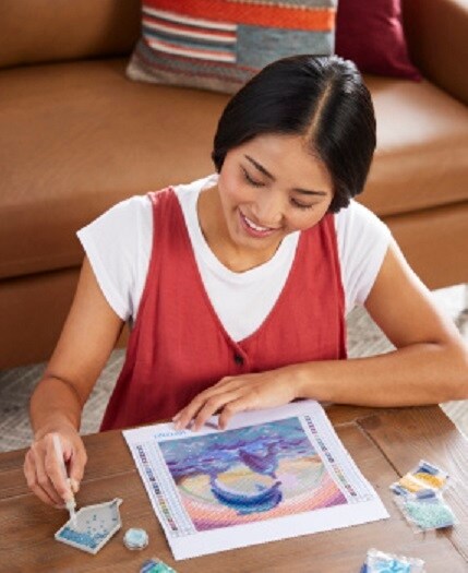 woman completing diamond art project