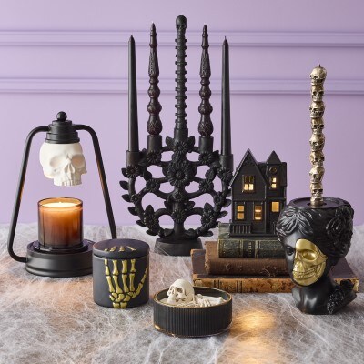 assorted hallloween spooky themed candle collection with candle warmers, candle holders, and candles