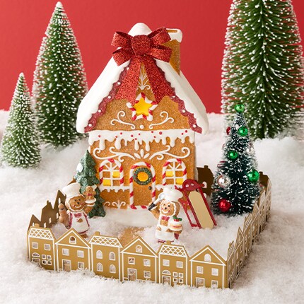 A gingerbread house with trees and snow