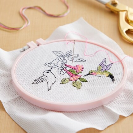 Projet de point de croix en cours avec un motif de colibri.