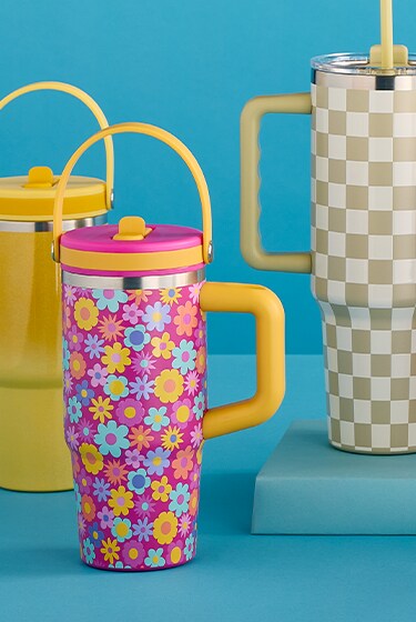 Tumblers of all sizes lined up against a blue backdrop. 