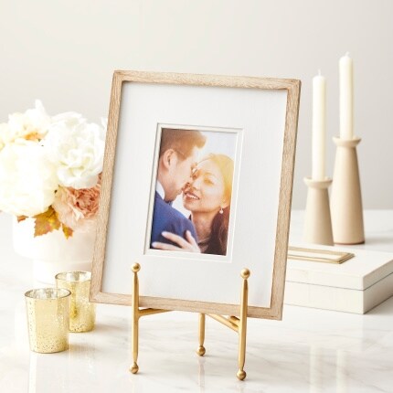 tabletop easel with framed photo of couple next to flowers and candles