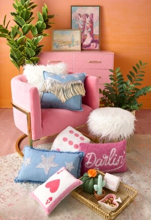 assorted western and card themed pillows with pink chair