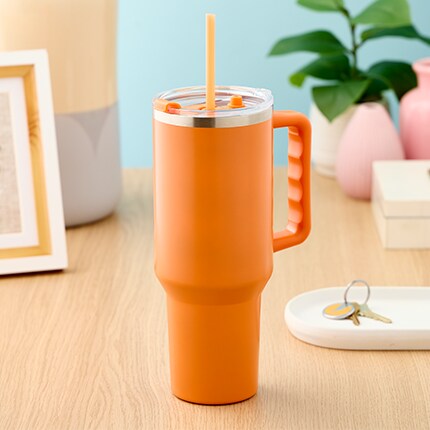 orange drinking tumbler on desk