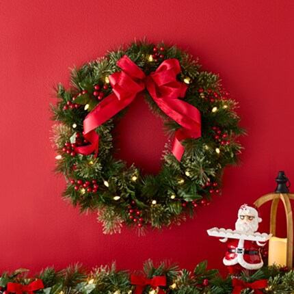 A wreath with red ribbon and lights