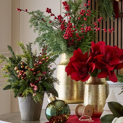 Holiday Stems and bushes in gold vases on a table