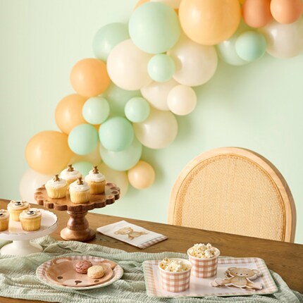 tan and light green and white balloon garland with teddy bear party supplies
