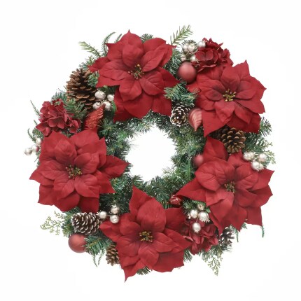 A lush Christmas wreath of red poinsettias, evergreen sprigs, pinecones, berries, and shiny ornaments sits against a white background, festive and welcoming.