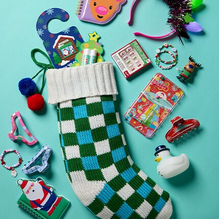 Kids stocking stuffers spilling out of a checkered blue stocking over a teal background. 