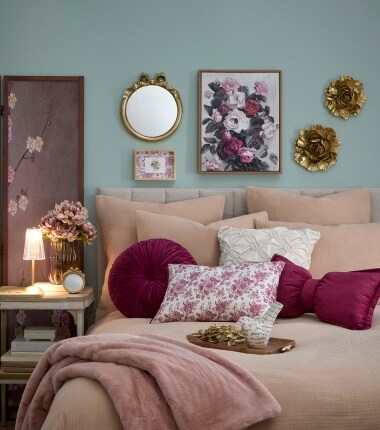 image of taupe bedding with burgundy pillows and gold and floral decor 