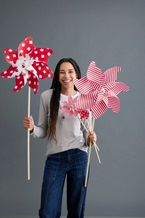 woman holding red and white pinwheels