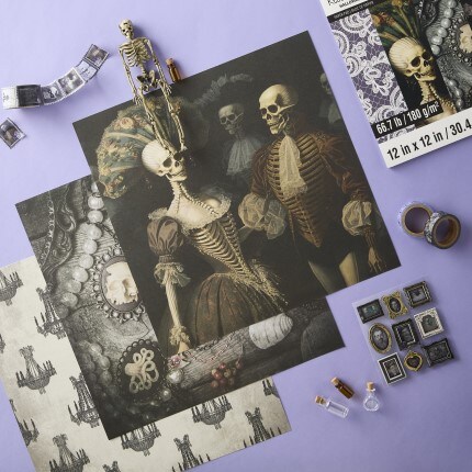 Halloween themed paper sheets with vintage skeleton art with mini embellishments, skeleton figurine, and crafting accessories on a lavender background  
