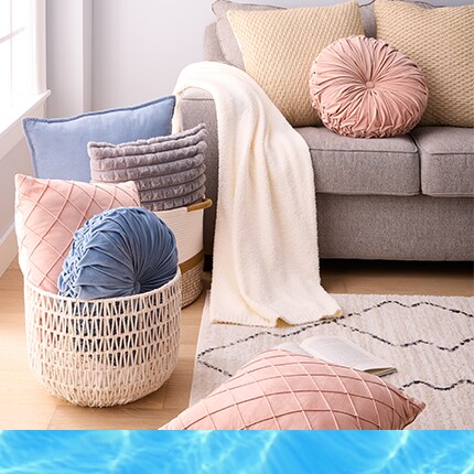 pillows and blankets in baskets in front of couch