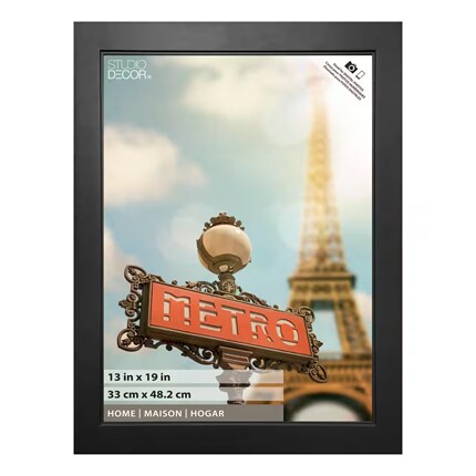 Vintage Paris poster in a black frame, featuring a red Métro sign, ornate streetlamp, Eiffel Tower, and soft blue sky; nostalgic tone.