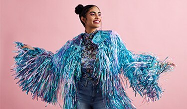 girl with bright blue fringe jacket and pink background