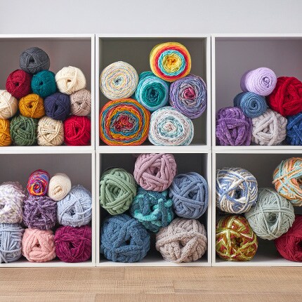 assorted yarn skeins in white cubbies