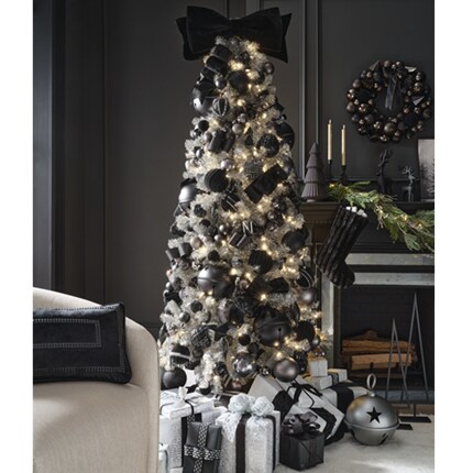 A Christmas tree with black and silver ornaments and presents