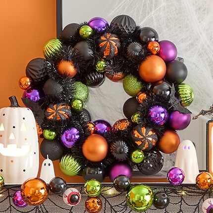 Halloween wreath made of black, orange and purple ornaments. 