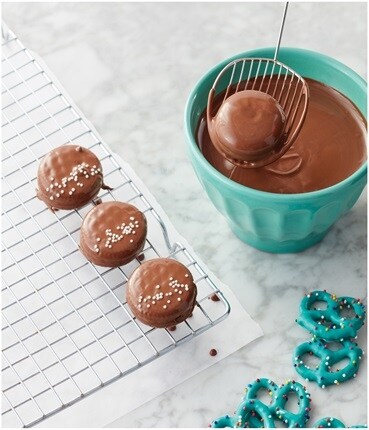 Chocolate on cooling sheet with turquoise bowl and pretzels