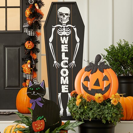 Halloween inspired decorations for the porch: skeleton welcome sign, pumpkin.