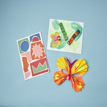 Kids construction paper art on blue background