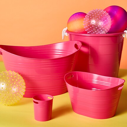 Pink plastic storage bins in various sizes for pool toys and outdoor storage