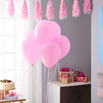 room with pink balloons and party decor by celebrate it