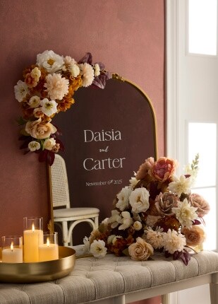 arched mirror wedding sign with orange and cream flowers on table