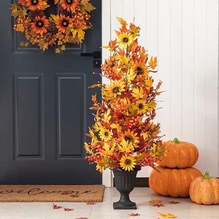 A plant in a vase with flowers and pumpkins