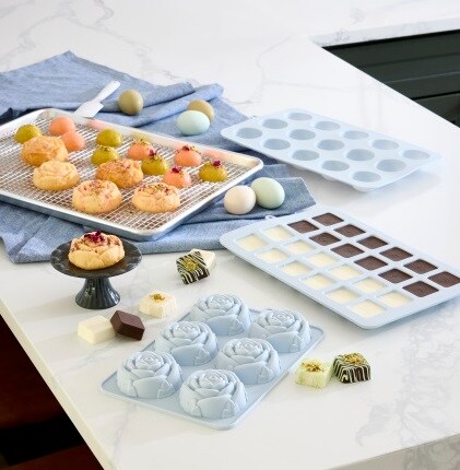 silicone molds, baking pan and treats on marble countertop